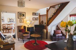 a living room with a staircase with chairs and a table at Higher Farm in Malpas