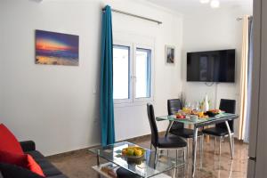 a living room with a table and chairs and a television at Luxury Lake - Center House in Agios Nikolaos