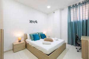 Un dormitorio con una cama grande con almohadas azules. en Brand new apartment in Sliema 2 min by the sea, en Sliema