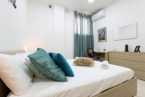 Un dormitorio con una cama con almohadas azules y blancas. en Brand new apartment in Sliema 2 min by the sea, en Sliema