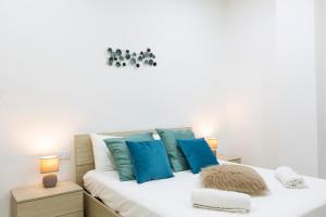 Un dormitorio con una cama blanca con almohadas azules. en Brand new apartment in Sliema 2 min by the sea, en Sliema