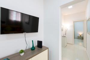 Una sala de estar con un televisor de pantalla plana en una pared. en Brand new apartment in Sliema 2 min by the sea, en Sliema 25 fotos más