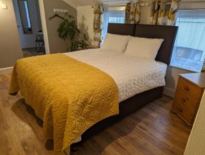 a bedroom with a large bed with a yellow blanket at Gull Wing Guesthouse in Lowestoft