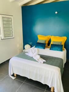 - une chambre avec un lit jaune et bleu dans l'établissement K'Noly, à Baie-Mahault
