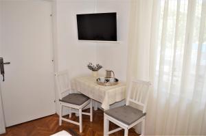 een kamer met een tafel en twee stoelen en een televisie bij Apartment Marija in Krk