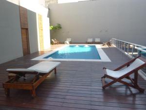 a swimming pool on a balcony with two chairs at Sissi Apart in Buenos Aires