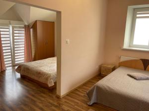sypialnia z 2 łóżkami i oknem w obiekcie Irena Apartaments w Połądze