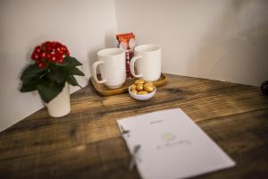 a table with two coffee cups and a vase with a plant at La Tissandière in Lalbenque