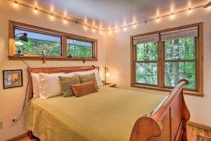 una camera da letto con letto e finestre con luci di Boone Cottage with Fire Pit and On-Site Creek! a Boone