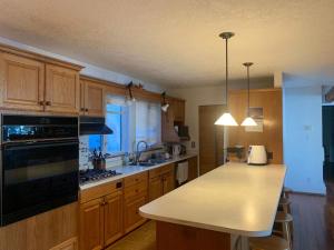 a kitchen with wooden cabinets and a white counter top at Metchosin Beach House in Victoria