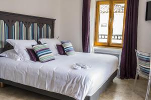 ein Schlafzimmer mit einem Bett mit Kissen und einem Fenster in der Unterkunft La Tissandière in Lalbenque