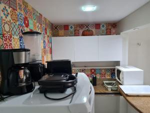 a kitchen with a stove with a pot on top of it at Lindo Estúdio vista mar com cama king in João Pessoa