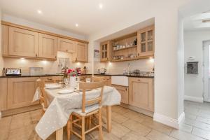 uma cozinha com uma mesa e cadeiras numa cozinha em Swift Cottage em Pateley Bridge