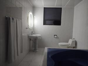 a bathroom with a tub and a toilet and a sink at Hotel Gilbert in Mexico City