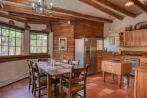 eine Küche mit einem Tisch und Stühlen sowie einem Kühlschrank in der Unterkunft Alfred's Hacienda & Casita in Taos