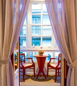 - une table et des chaises dans une chambre avec fenêtre dans l'établissement Hotel Herradura, à Saint-Jacques-de-Compostelle