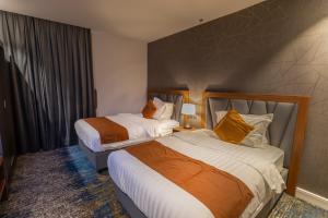 دانة المروج للأجنحة الفندقية Danat Almourouj Hotel Suites tesisinde bir odada yatak veya yataklar