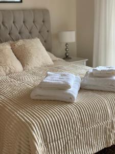 three towels are stacked on top of a bed at Arena1 in Mar del Plata