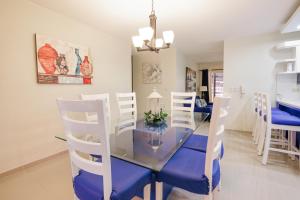 a dining room with a glass table and white chairs at DOLCE VILLAS AT HARMONY 2 in Santiago de los Caballeros