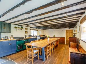 uma cozinha com uma mesa de madeira e armários azuis em Pant Dafydd Goch em Llansantffraid Glyn Ceiriog