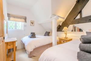 a bedroom with two beds and a window at Fern Hall Cottage in Upper Welson