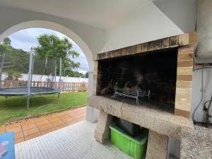 a patio with a stone fireplace and a swing at Villa Poexa in Rosal