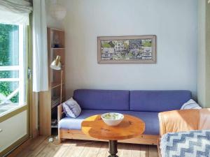 uma sala de estar com um sofá azul e uma mesa em 5 person holiday home in FLODA em Floda