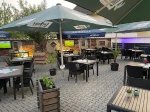 a patio with tables and umbrellas in a restaurant at Hotel Anker in Großenlinden