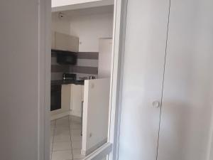 Una pequeña cocina con gabinetes blancos y un refrigerador. en City Break en centre-ville, proche commodités et sites naturels - FR-1-585-77, en Bar-le-Duc 2 fotos más