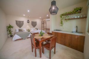 eine Küche und ein Wohnzimmer mit einem Tisch und einem Sofa in der Unterkunft Mayanah Bacalar in Bacalar