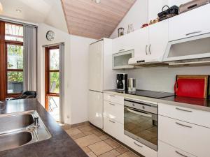 eine Küche mit weißen Schränken und einem Waschbecken in der Unterkunft 8 person holiday home in R m in Rømø Kirkeby