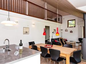 eine Küche und ein Esszimmer mit einem Holztisch und Stühlen in der Unterkunft 8 person holiday home in R m in Rømø Kirkeby