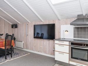 a kitchen with a flat screen tv on the wall at 6 person holiday home in R m in Rømø Kirkeby