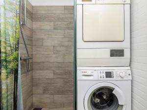 uma máquina de lavar roupa na casa de banho ao lado de um chuveiro em Holiday home Hals CXXI em Hals