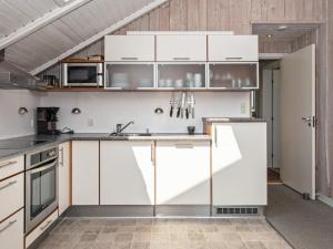 a kitchen with white cabinets and a sink at 6 person holiday home in R m in Rømø Kirkeby