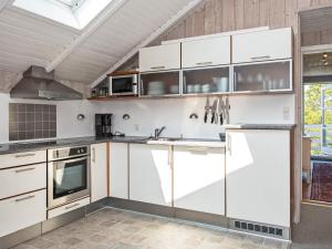 a kitchen with white cabinets and a stove at 6 person holiday home in R m in Rømø Kirkeby
