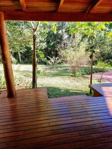 a wooden deck with a view of a park at OMA CHILL HOUSE IGUAZU in Puerto Iguazú