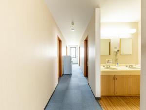 Naoetsu的住宿－Tabist Ryosou Minatosou Joetsu，走廊上的厨房配有水槽和冰箱
