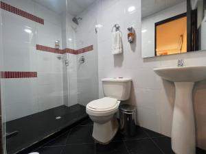 y baño con aseo, lavabo y ducha. en Hotel Ferias Park, en Bogotá