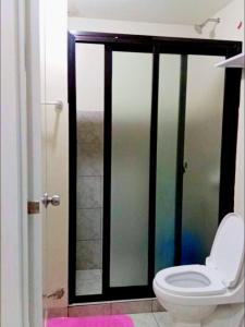 a bathroom with a toilet and a shower stall at Calm & Cozy Hideaway in Tunkong Manga