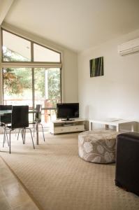 a living room with a bed and a table and chairs at Rivergum Holiday Park in Corowa