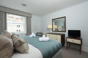 a bedroom with a bed with a mirror and a television at 9 Dart Marina in Dartmouth