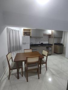 a kitchen with a table and chairs in a room at Iguaçu Hospedagem in Foz do Iguaçu