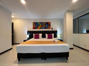 a bedroom with a large bed and a painting on the wall at Hotel Ferias Park in Bogotá