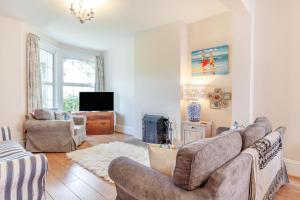 a living room with a couch and a tv at Downlea in Looe