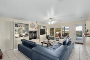 ein Wohnzimmer mit einem blauen Sofa und einem Tisch in der Unterkunft Hot Tub, Heated Infinity Pool, Perfect Hill Country Estate on 10 Acres in Jonestown