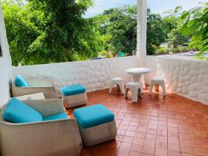 Un balcón con sillas, mesas y una mesa. en BTC Boutique Resort Private Pool Villas Hua Hin บ้านทะเลจีน บูติค รีสอร์ท หัวหิน en Hua Hin