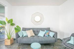 un soggiorno con divano grigio e specchio di Appartement B François a Le François 1 altra foto