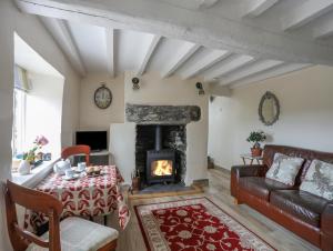 a living room with a fireplace and a couch at Little House in Llandecwyn