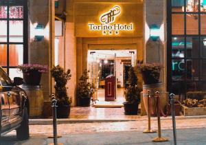 a torino hotel entrance with a car parked in front of it at Torino Hotel Amman in Amman